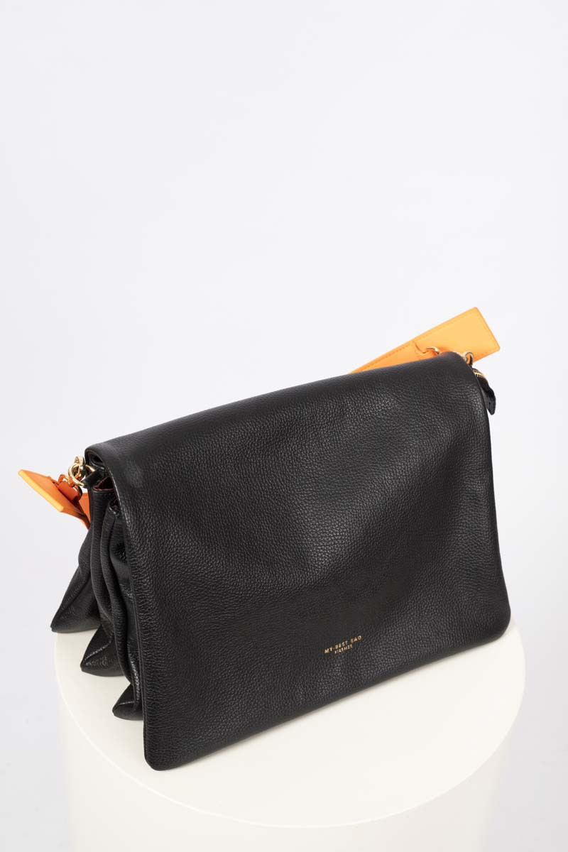 Black flap bag with orange shoulder strap